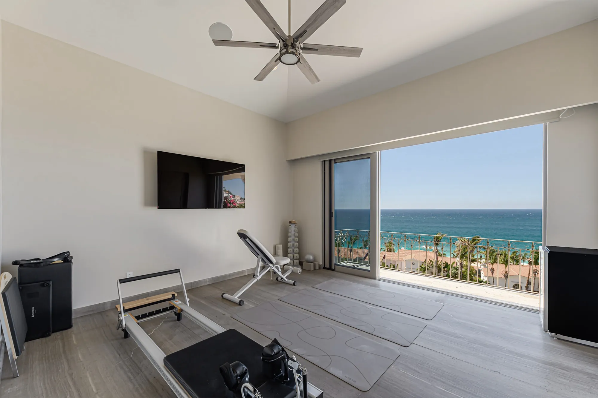 A room as it is today, set up as a gym, glass opening to the sea.