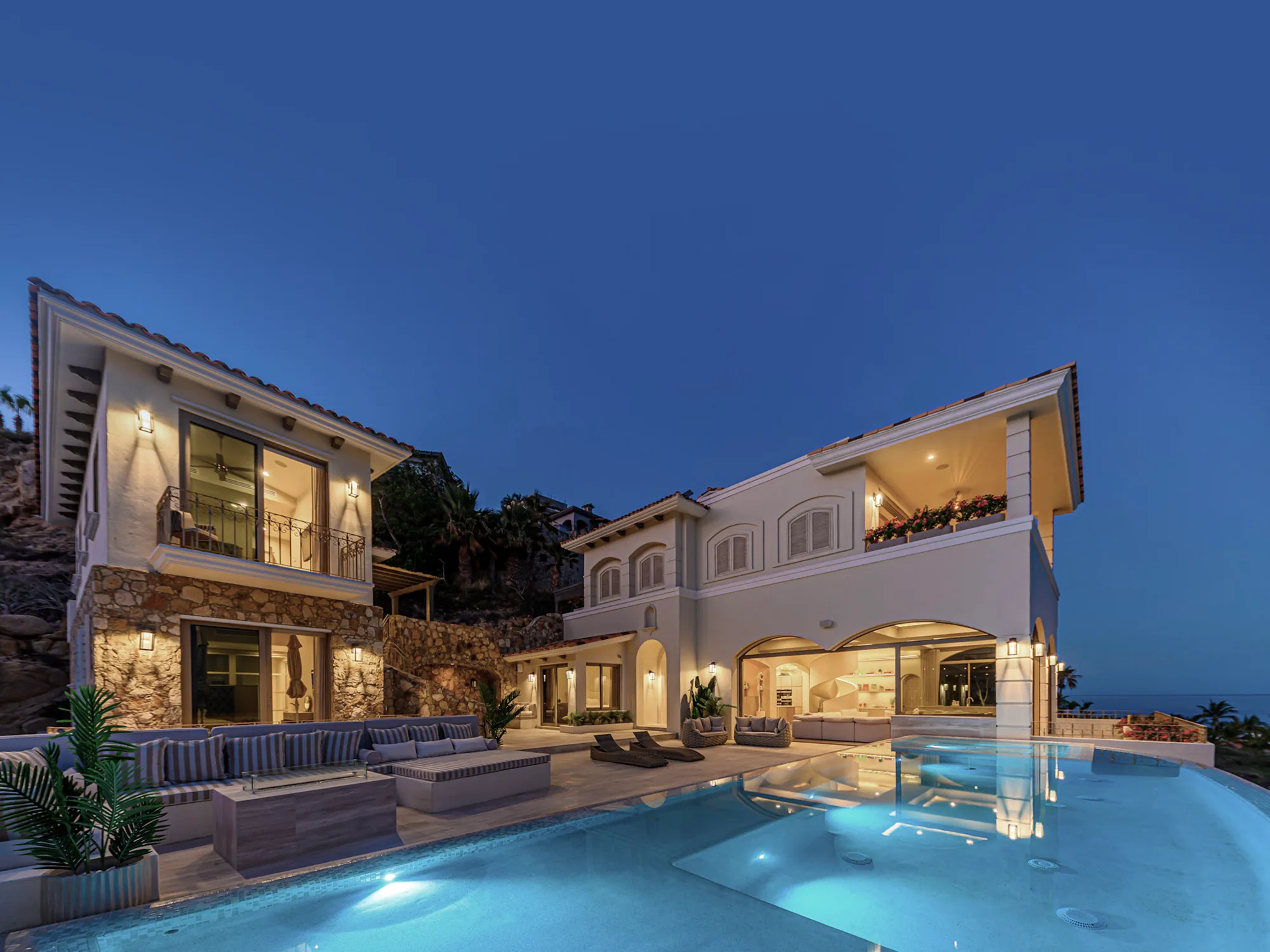 Villa Laura at dusk, the pool terrace and lit interiors above the Sea of Cortez.