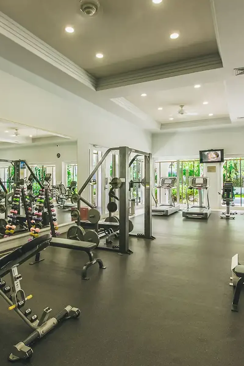 The community fitness centre, light-filled with weights and machines opening to the gardens.