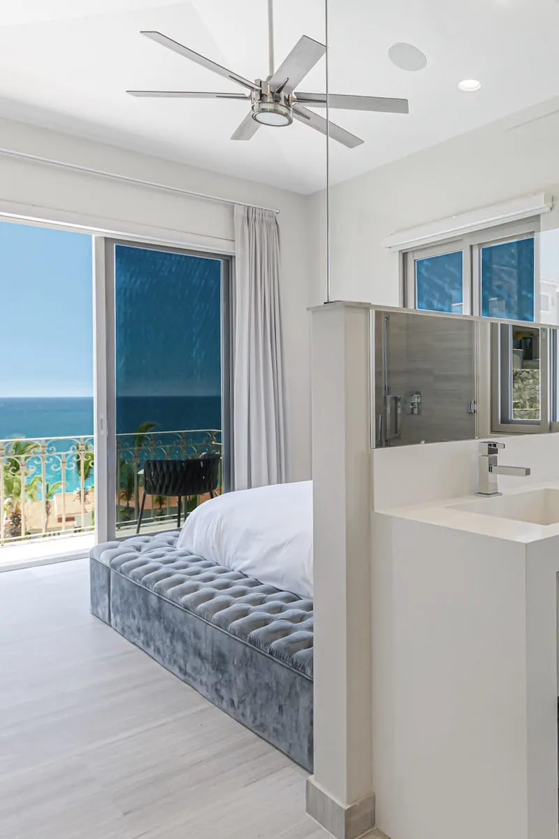 A bedroom in the private casita, sliding doors to a sea-view balcony and its own bath.