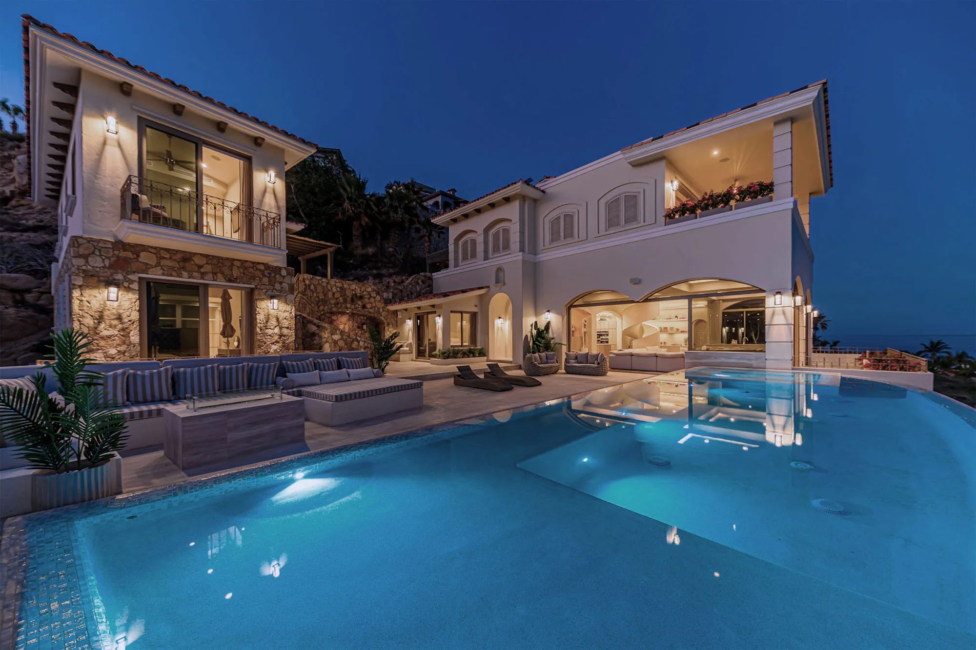 Villa Laura at dusk, the lit residence above its infinity pool, the Sea of Cortez beyond.